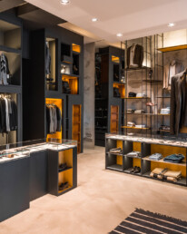 Interno del negozio Effero Uomo a Milano Marittima, con arredo espositivo nero, strutture in metallo e nicchie illuminate
