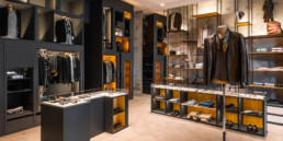 Interno del negozio Effero Uomo a Milano Marittima, con arredo espositivo nero, strutture in metallo e nicchie illuminate